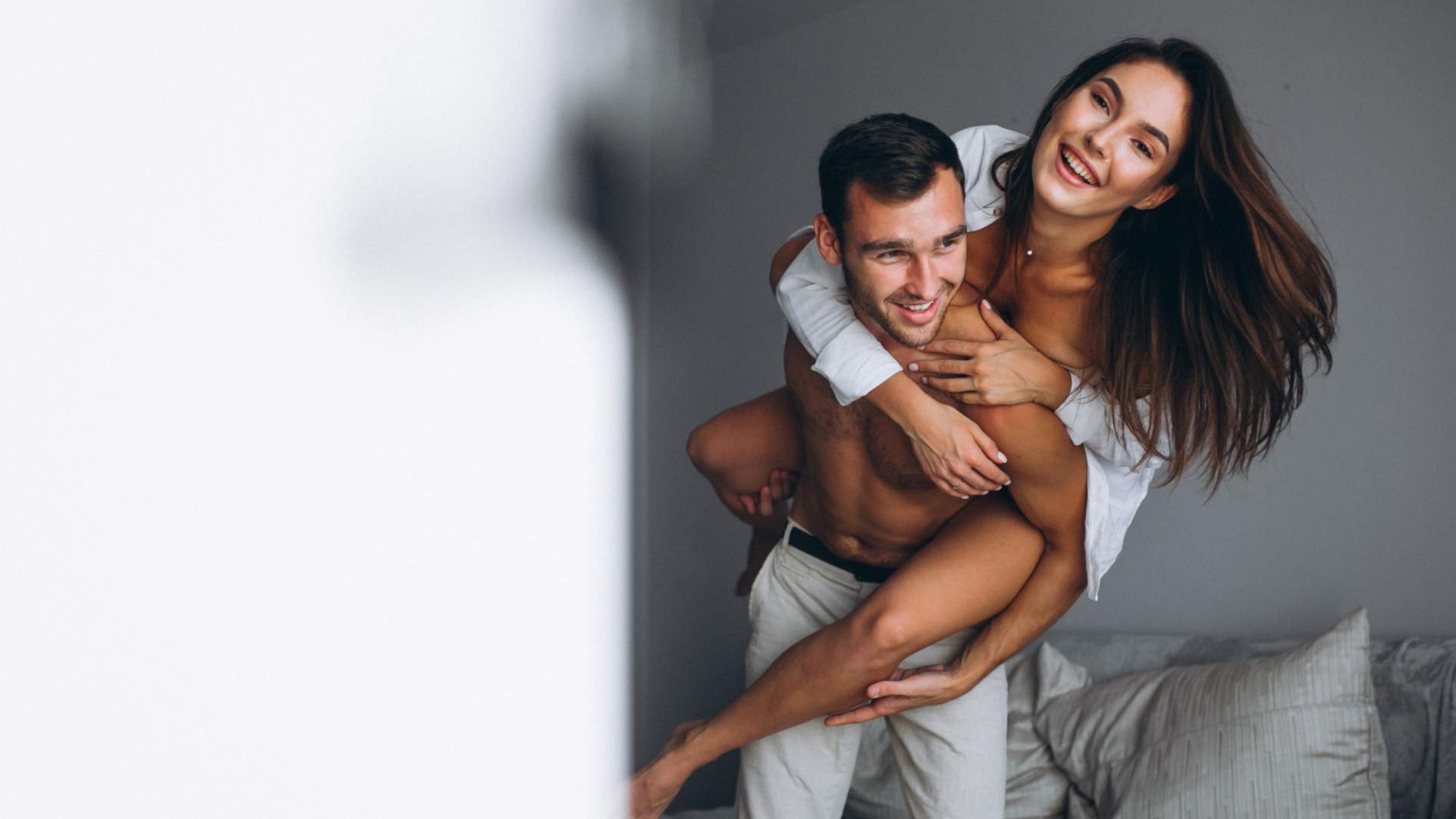 Man carrying his partner in the bedroom during Couples Retreat Experiences